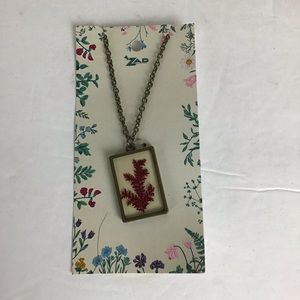 Necklace with red leaves in glass.